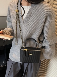 Vintage black textured mini box bag with gold chain strap shown on a model