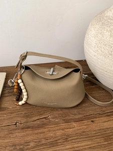 Khaki pebbled leather hobo bag with top handle, crossbody strap, and beaded charm