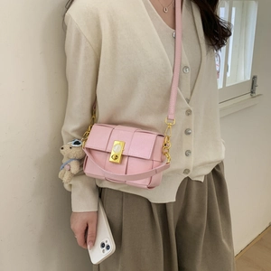 Sac bandoulière rose à carreaux avec fermoir rotatif doré et détail d'ourson en peluche