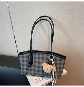 Close-up of black and grey checkered tote bag featuring a cute plush bear and silk scarf