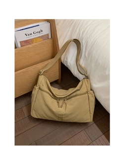 Detail of khaki nylon tote bag showing double front zipper pockets and adjustable strap