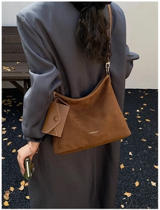 Brown suede hobo bag on shoulder showing large capacity and mini pouch detail