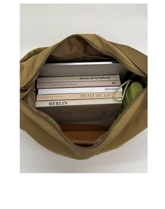 Spacious interior of a khaki tote bag holding a laptop, books, and a green umbrella