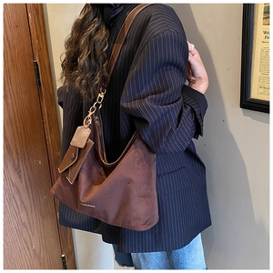 Detail of dark brown suede hobo bag with gold hardware and matching coin purse charm