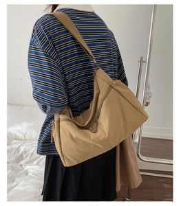 Detail of khaki canvas tote bag showing wide adjustable shoulder strap and durable fabric