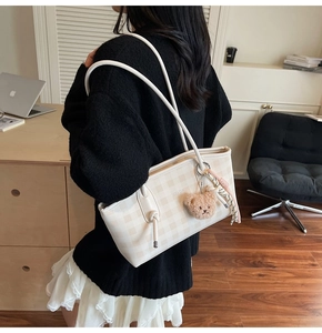 Détail du sac cabas à carreaux crème avec breloque ours en peluche et foulard en soie
