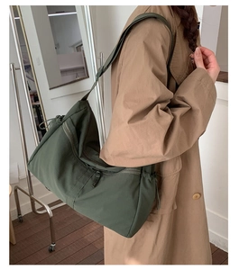 Detail of army green nylon dumpling bag showing drawstring texture and adjustable strap