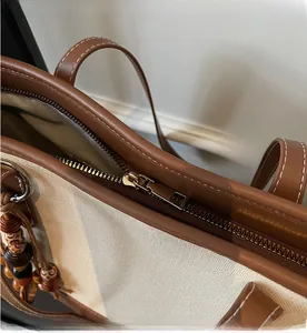 Detail of premium metal zipper on canvas and leather tote with wood bead charm