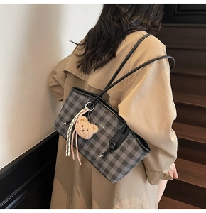 Détail du sac cabas à carreaux gris avec breloque ours et fines lanières noires