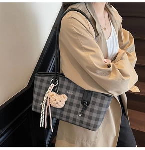 Détail du sac cabas à carreaux gris avec imprimé lettres et porte-clés ours brun