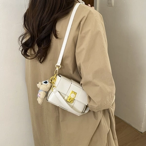 Détail du sac bandoulière blanc à carreaux avec fermoir doré et breloque ourson