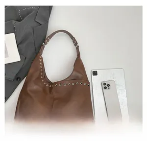 Detailed view of the large brown vintage hobo bag shown with a tablet and phone for size