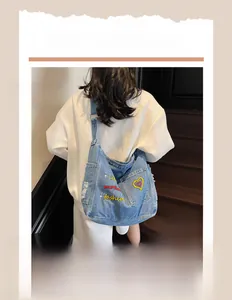 Hobo style denim tote bag with fashion embroidery worn by model on stairs