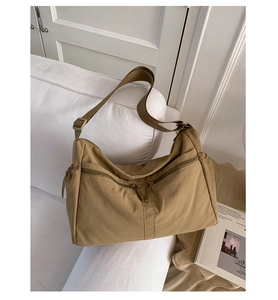 Detail view of khaki nylon dumpling bag with multi-zipper pockets and adjustable wide strap