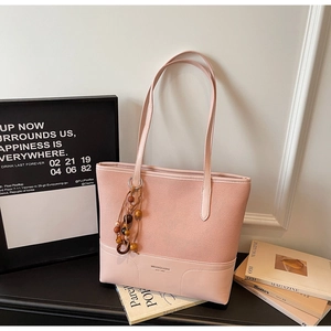 Dettaglio della borsa tote patchwork rosa con trama in pelle scamosciata e ciondolo di perle