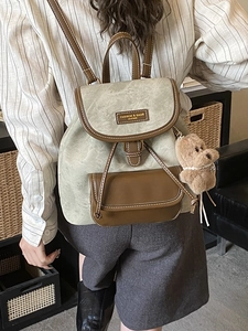 Vintage green suede and brown leather backpack with bear charm shown on model