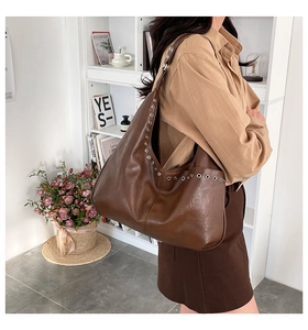 Détail du sac cabas marron vintage avec œillets métalliques argentés et bandoulière large
