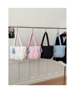 Detailed view of quilted puffer tote bags in four colors with cute bear charm accessories