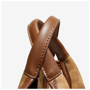 Detail of premium brown leather handle and heavy canvas texture with neat stitching