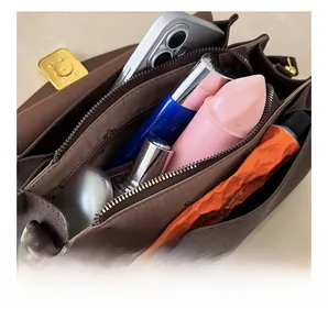 Interior view of brown leather square bag showing compartments for phone and cosmetics