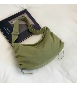 Détail du sac demi-lune vert herbe en nylon plissé avec accents de cordon de serrage