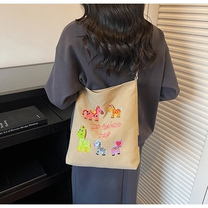 Detailed embroidery on khaki canvas tote bag featuring colorful cute cartoon animals