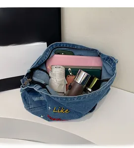 Spacious interior of denim tote bag showing tablet, umbrella, and water bottle