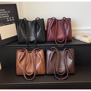 Vue détaillée montrant la texture tressée et les couleurs des sacs cabas exposés