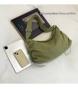 Sac hobo en nylon vert olive avec iPad et smartphone pour comparer la taille et capacité
