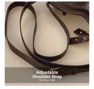 Detail showing the adjustable slim leather shoulder strap with golden metal buckle