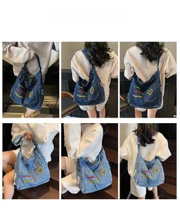 Detail of embroidered denim tote bag showing colorful heart pattern and frayed edge pocket