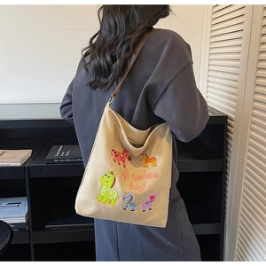 Detail of cute animal embroidery and brown leather strap on beige canvas tote bag
