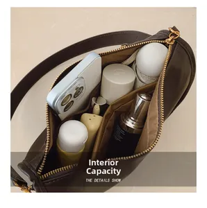 Detail of the brown vintage shoulder bag's spacious interior with golden zipper