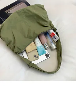 Intérieur spacieux d'un sac hobo en nylon vert contenant une tablette et un portefeuille