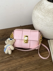Sac bandoulière chic en cuir tissé rose avec fermoir doré et breloque ours sur bois