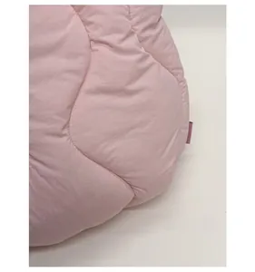 Detail view of pink quilted fabric with wavy stitching and soft padded texture on tote bag