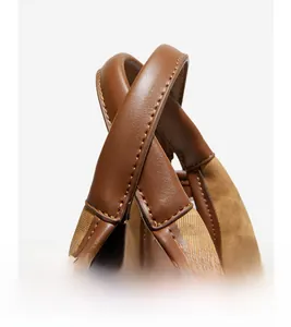 Close-up of brown leather handles and canvas texture with contrast stitching detail