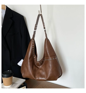 Vue détaillée du grand sac hobo marron foncé en cuir vintage avec des œillets argentés