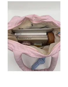Spacious pink quilted tote bag showing interior capacity with books and laptop