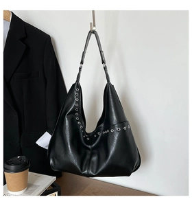 Détail du sac Hobo rétro noir avec œillets métalliques argentés et similicuir lisse