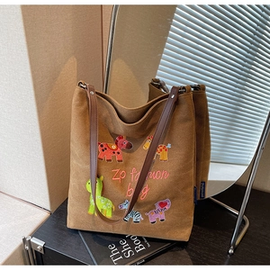 Detail of cute animal embroidery and sturdy brown straps on large canvas tote bag