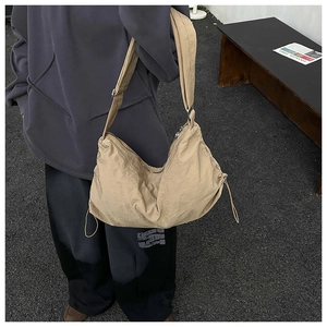 Gros plan sur la bandoulière réglable et la texture en nylon kaki de ce sac bandoulière