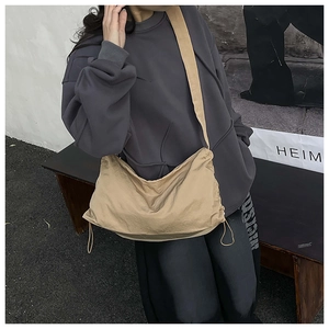 Gros plan du sac en nylon kaki montrant le cordon de serrage réglable et la texture latérale