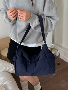 Sac bandoulière en nylon bleu foncé avec poches multiples et sangle réglable