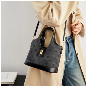 Macro shot of grey embossed suede and black leather detail with gold metal twist lock