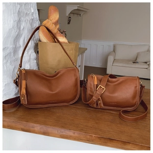 Detailed view of brown PU leather handbags with golden zippers and leather tassels