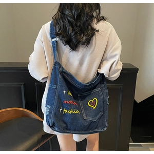 Detailed embroidery of Love and stars on a vintage blue denim tote bag with side pocket
