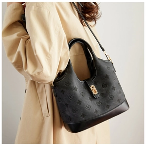 Detail of black jacquard bucket bag with gold clasp and elegant swan pattern