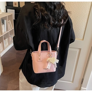 Pink glossy patent leather mini bucket bag with pearl heart pendant and shoulder strap