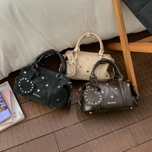 Detailansicht der Boston-Taschen in Schwarz, Beige und Braun mit Sternnieten und Herzanhängern